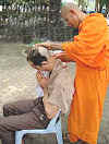 One of the monk's finishes the haircut!